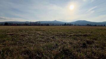 A tranquil view of vast fields with rolling hills and a glowing sun, perfect for nature-themed projects. photo