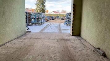 The picturesque view from an open doorway provides a glimpse of a snowy outdoor storage area filled with various items photo