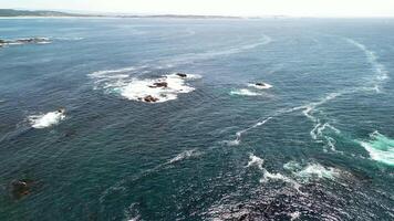 Captivating and stunning aerial footage displaying a vibrant ocean showcasing rocky formations and swirling waves photo