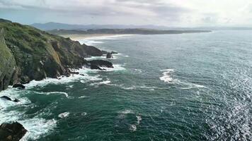 Experience breathtaking coastal landscapes filled with crashing waves and lush verdant cliffs reaching skyward photo