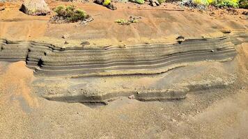 Embark on a journey to discover unique geological formations showcasing layered textures found in coastal landscapes photo
