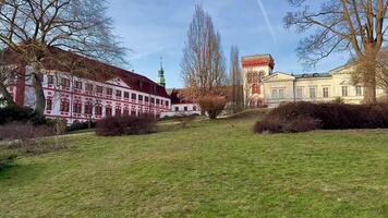 A beautiful scenic view showcases historic buildings set against a lush green landscape under a clear, bright sky photo