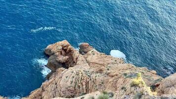 Breathtaking ocean scenes featuring waves forcefully crashing against rugged cliffs and relaxing, tranquil waters photo