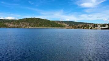 A serene lake view with lush green hills and blue skies, perfect for nature lovers seeking tranquility photo