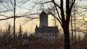 A breathtaking castle nestled among the winter trees during a sunset, evoking enchanting dreams of fairy tales photo