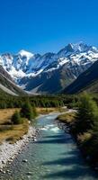 Turquoise River Flowing Through Alpine Valley with Snow-Capped Mountains and Meadows photo