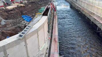 This construction project involves creating a water channel along with the necessary surrounding structure for it photo