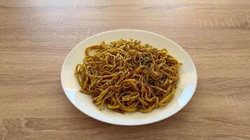 Enjoy a spicy noodle bowl, garnished with colorful fresh vegetables, perfect for quick, satisfying meals anytime photo