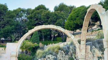 The beautiful stone arches, framed by vibrant and lively trees, create a truly serene and calming landscape photo