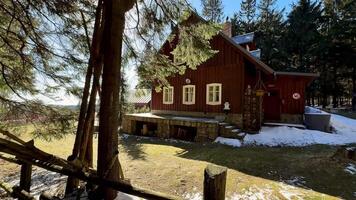 A beautifully serene red cottage snugly nestled in the woods, an ideal spot for a peaceful escape into nature photo