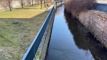 A tranquil stream with lovely fencing, green grass, and vibrant nature, perfect for peaceful reflection and relaxation photo