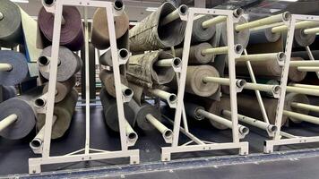 Organized storage of various media rolls on racks, showcasing material diversity in a comprehensive layout. photo