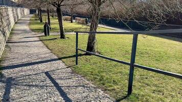 A scenic park path with lush trees and a solid railing, perfect for recreation and peaceful relaxation photo