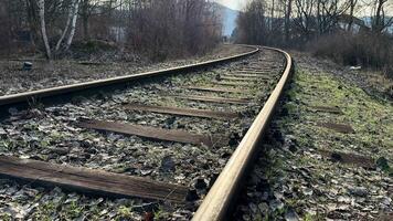 A beautiful and serene view of longabandoned railway tracks winding through a vast and overgrown landscape photo