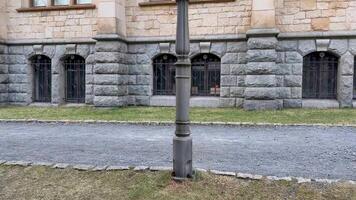 A street scene featuring a vintage lamp post with stunning historic stone architecture in the background photo
