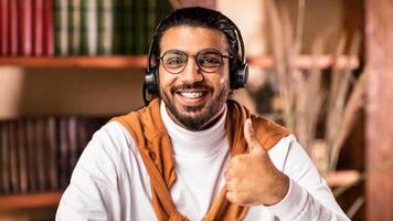 I Like E-Learning. Happy Indian Male Student Gesturing Thumbs Up To Camera Approving Educational Online Course Sitting At Home. Distance Learning, Remote Study And Modern Education photo
