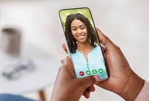 Pov of black person holding cell phone in hand calling online and talking with woman looking on mobile screen using smartphone videochat app, staying at home, closeup view, selective focus photo