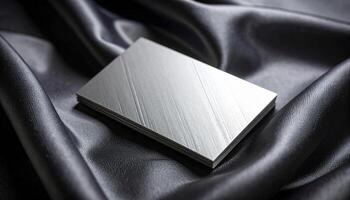 Silver Foil Business Card With Symmetrical Deboss Pattern On Satin Fabric Reflective Quality photo