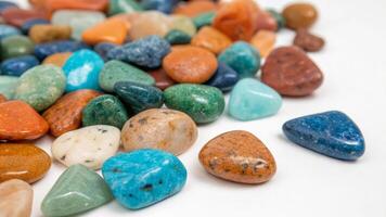 A pile of colorful stones on a white surface photo