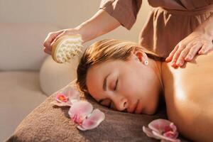 Therapist uses a spiked massage tool to gently stimulate the woman's scalp during a calming spa session, enhancing circulation, relaxation, and stress relief in a tranquil setting. photo