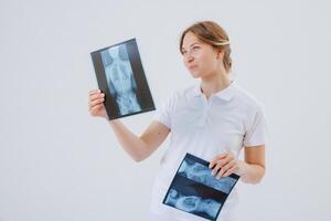 Rehabilitation Specialist Examines Spine X Rays for Scoliosis, Deformities, Injury, or Spinal Disorders photo