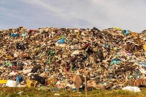 Extensive Landfill Site Overflowing with Discarded Waste Under a Cloudy Sky photo