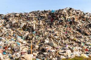 Massive Accumulation of Garbage and Waste Materials in Landfill Site Under Clear Sky photo