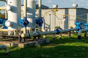 Pipeline System with Valves and Tanks at Industrial Processing Plant in Sunlight photo