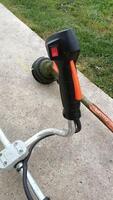 This is an Electric String Trimmer Handle that comes equipped with a cutting head for grass photo