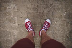 Casual Red Sneakers on Cobblestone Path Capturing Urban Exploration Mood photo