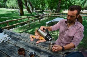 Father and Child Enjoying a Relaxing Outdoor Picnic Amidst Nature photo