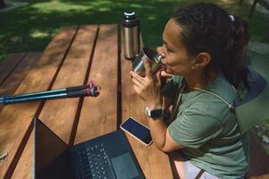 Digital Nomad Working Outdoors in a Mountain Setting with Laptop and Beverage photo