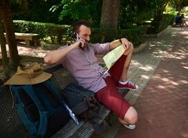 Man Relaxing on a Bench with a Map in a Park Setting photo