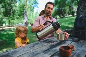 Father and Child Enjoying Outdoor Leisure at a Park Picnic Table photo