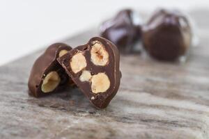 Decadent Chocolate Hazelnut Clusters on Marble with chopped hazelnuts embedded within the chocolate closeup side view of dessert snack photo