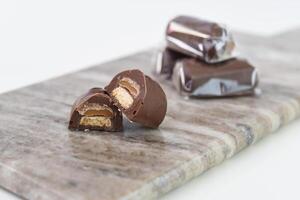 Decadent Chocolate Caramel Shortbread Bites gooey caramel layer atop a crumbly biscuit base on grey slate side view of delightful dessert photo