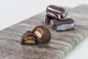 Decadent Chocolate Caramel Shortbread Bites gooey caramel layer atop a crumbly biscuit base on grey slate side view of delightful sweet photo