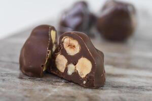 Decadent Chocolate Hazelnut Clusters on Marble with chopped hazelnuts embedded within the chocolate closeup side view of sweet snack photo