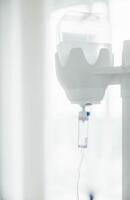 closeup of medical intravenous fluid drip chamber, hospital environment, sterile transparent container with clear liquid, tubing, healthcare treatment, emergency care, medical supplies photo
