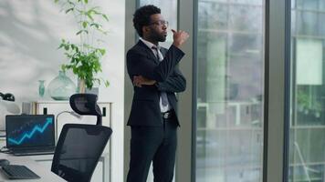 Pensive African American business man thinking in office looking out window create solution ethnic businessman male professional think idea decide work difficult thoughts pondering startup strategy video