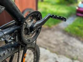 Close-up of bicycle crankset and pedal showing wear and tear photo