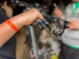 Mechanic holding a dirty bicycle fork during maintenance in workshop photo