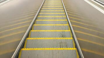 Empty Yellow-Lined Escalator Steps in Urban Subway Station photo