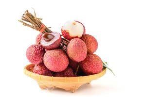 Juicy Lychee with cut in half and leaves on bamboo basket isolated on white background. Thai fruits. photo