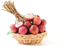 Juicy Lychee with cut in half and leaves on bamboo basket isolated on white background photo