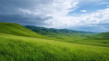 Lush green hills under dramatic cloudy sky with rolling terrain, dense grassy fields, and distant mountains in a wide natural landscape. photo