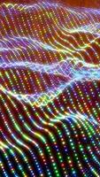 Abstract rainbow waves composed of multicolored glowing dots in a dynamic fluid pattern video