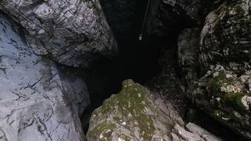 Aerial view of a scientific instrument being lowered into a 188-metre natural cleft in a mountain, Nikolina Jama, Montenegro video