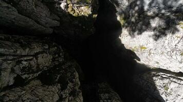 A drone takes off from a bottomless 188-meter pit onto a plateau. Natural crevice, Nikolina pit, Montenegro, Aerial view video