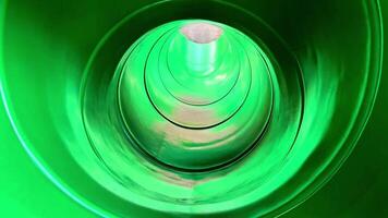 Experience the rush of a green water slide twisting through a glowing tube, as a daring individual slides down illuminated by vibrant lights video